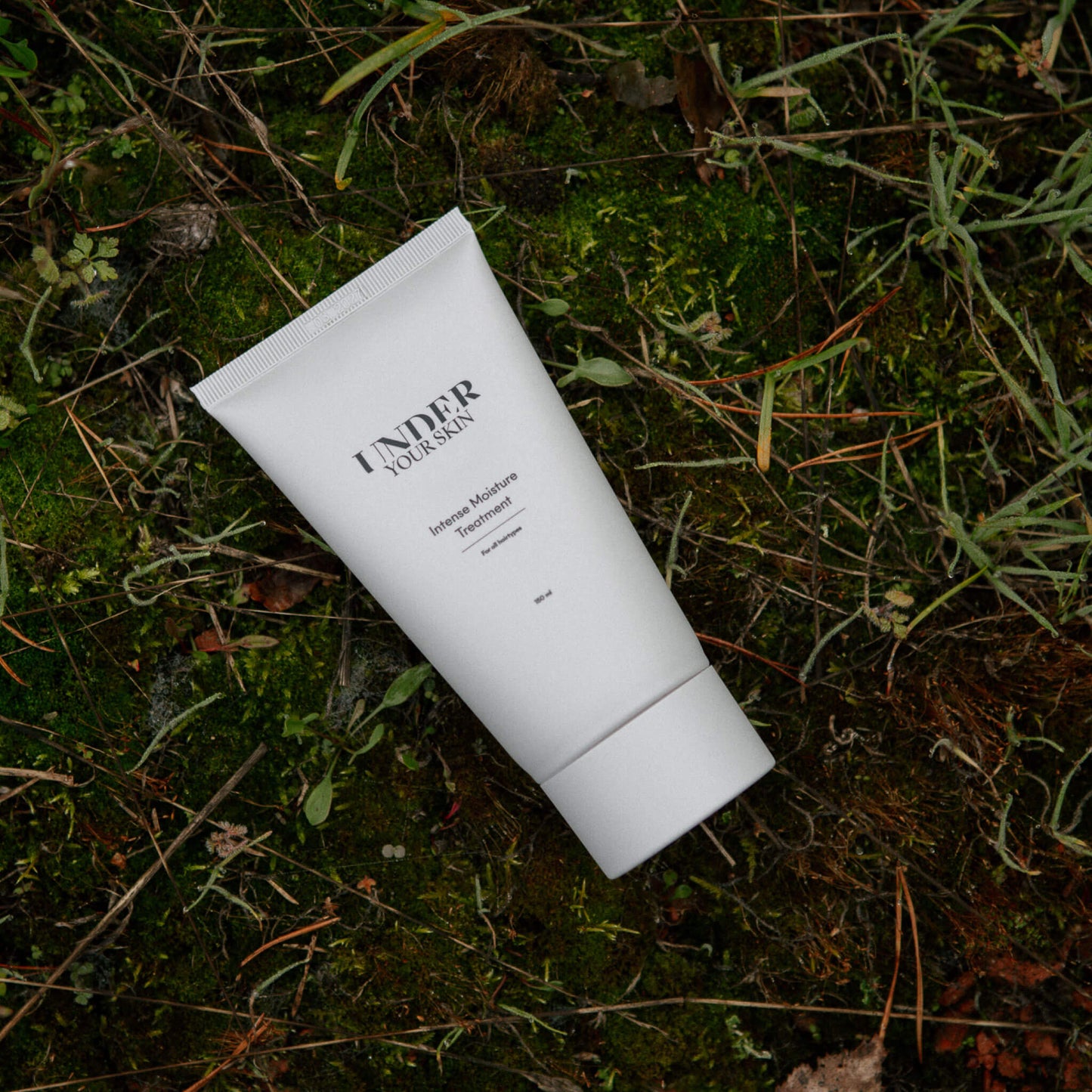 Hårmask placerad på naturmark med gräs och löv i en utomhusmiljö.