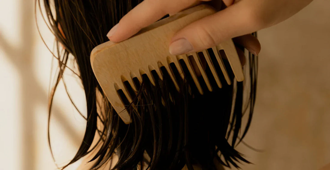 Close-up of hair being combed with a wooden comb