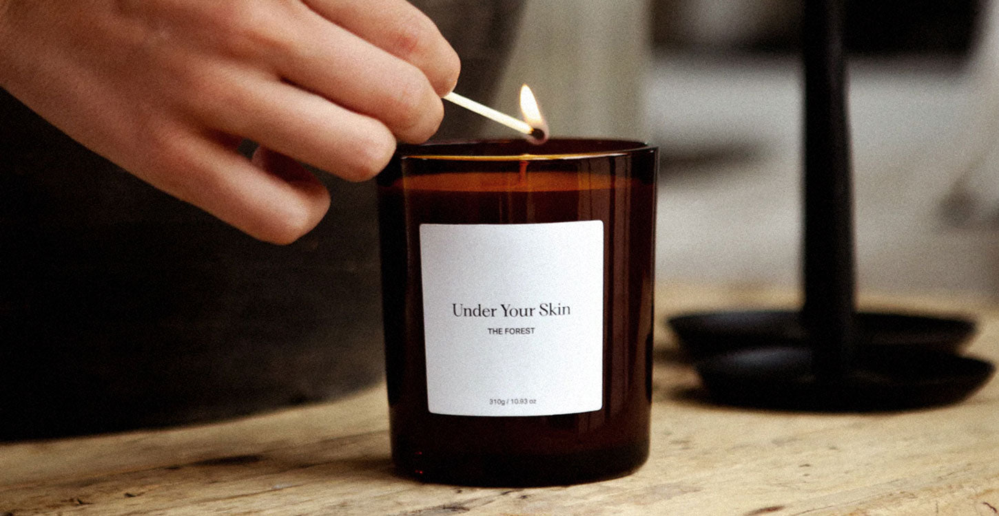 Lifestylebild på en Under Your Skin-ljus som tänds med tändstickor.