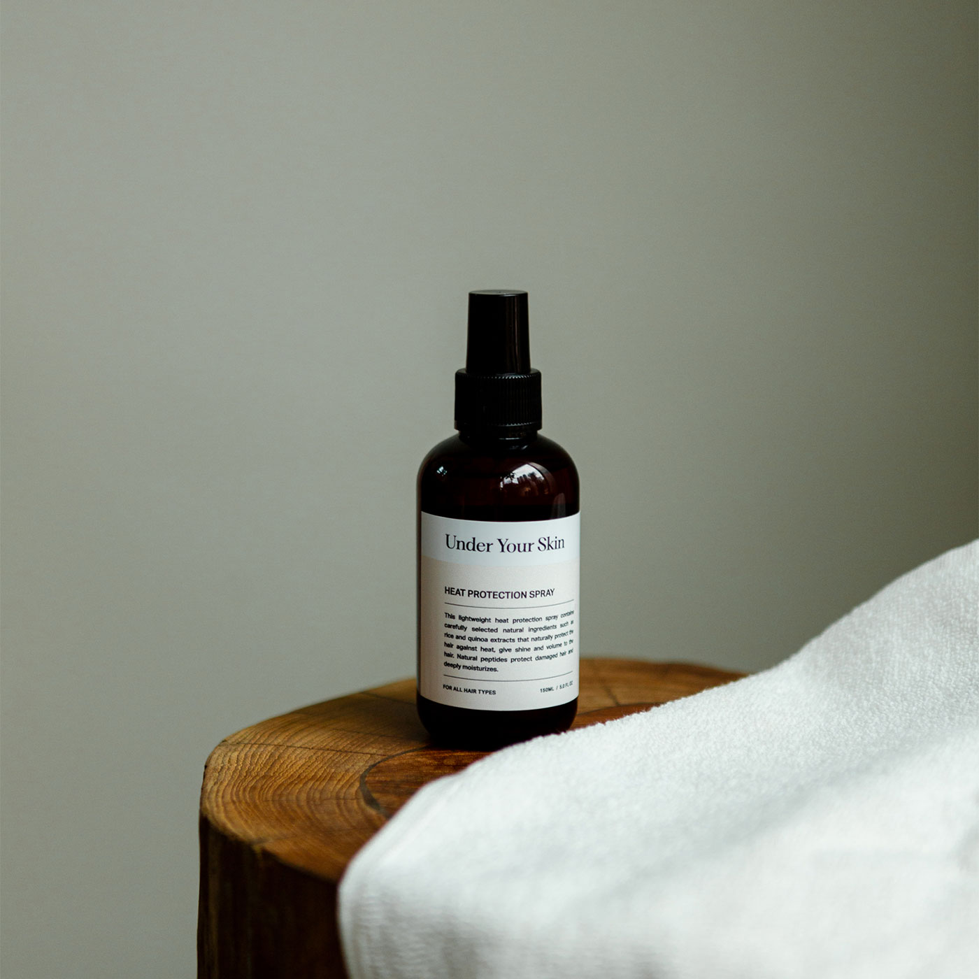 Värmeskydd för håret på en träbänk med en handduk bredvid