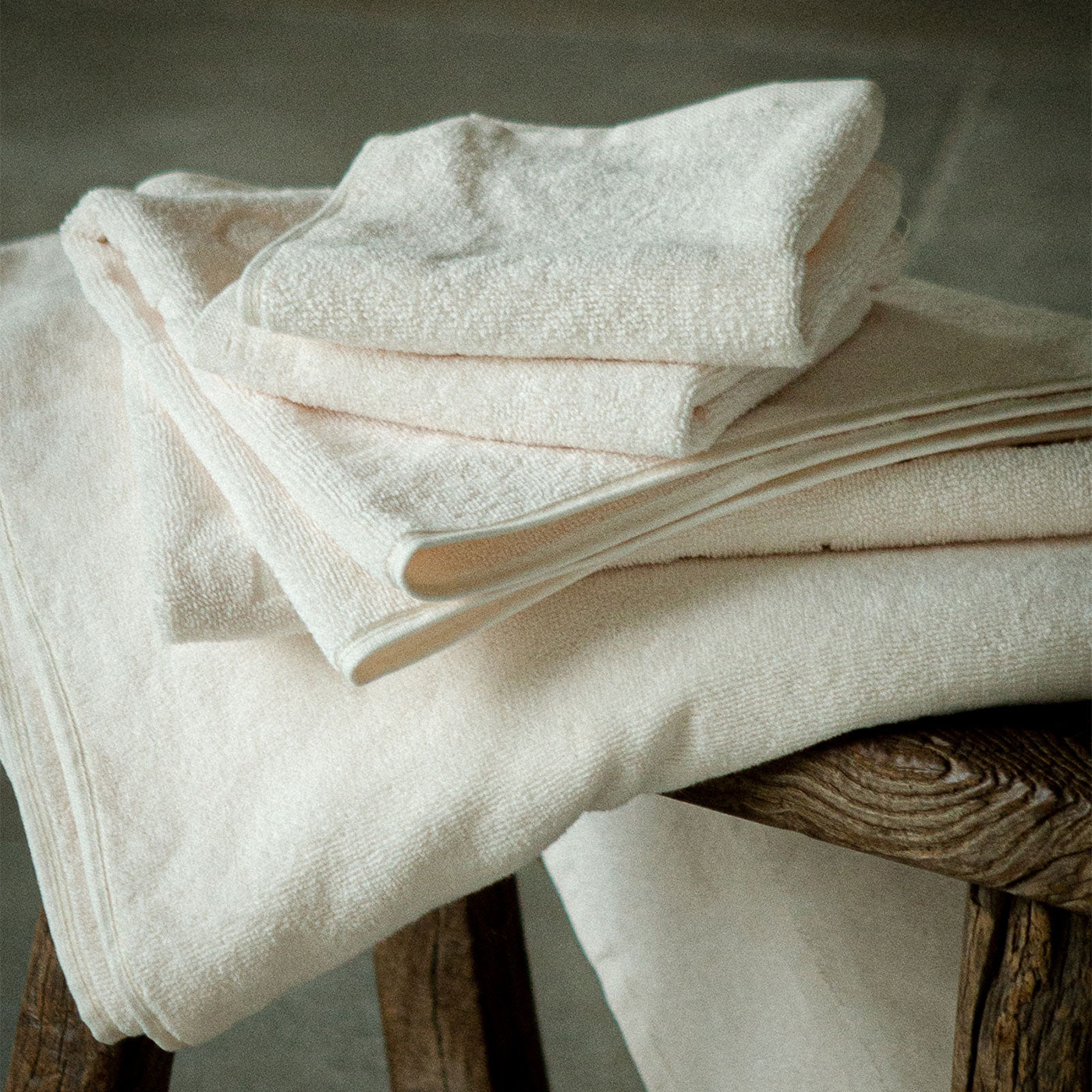 Vita badhanddukar staplade på varandra på en bänk.