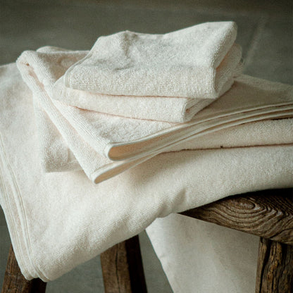 Vita badhanddukar staplade på varandra på en bänk.