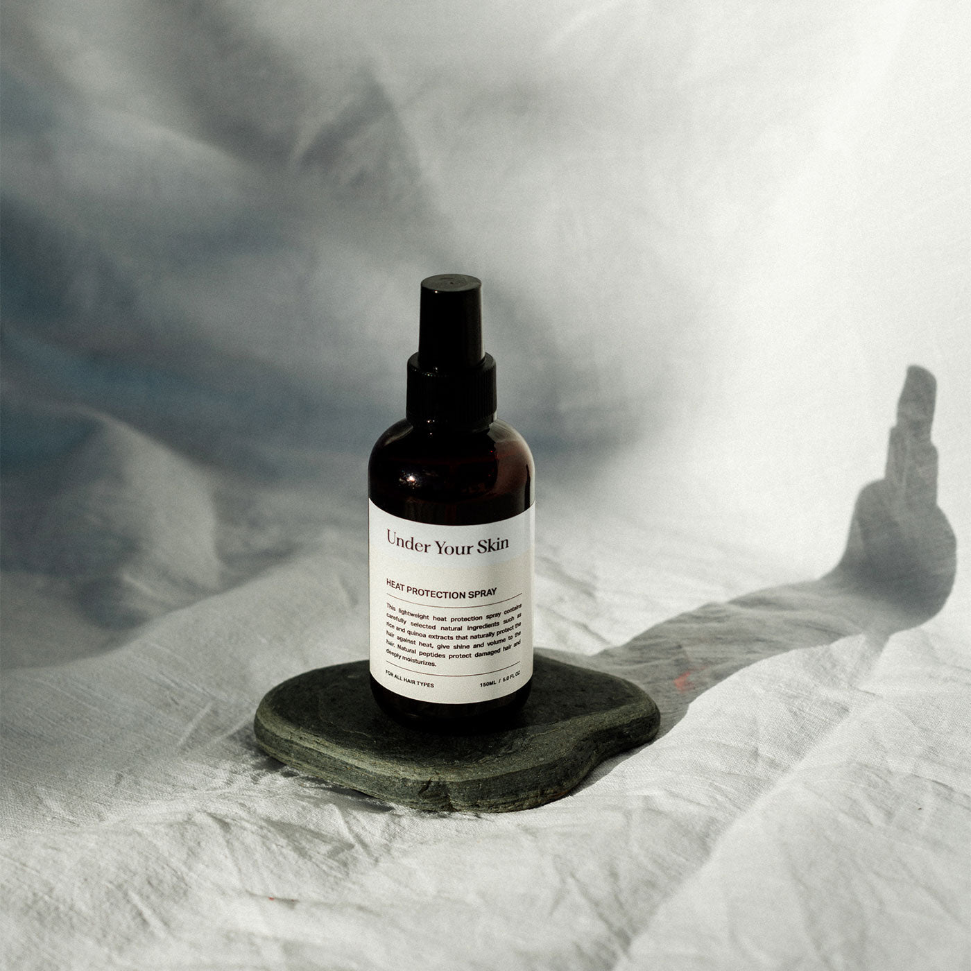 Värmeskydd för håret på vit bakgrund med skuggor