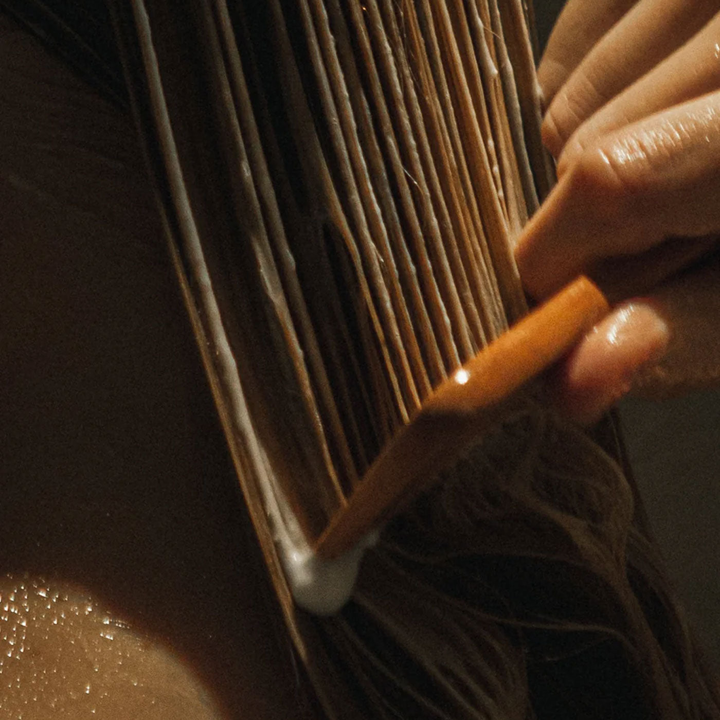 Närbild på hår som kammas med en träkam.