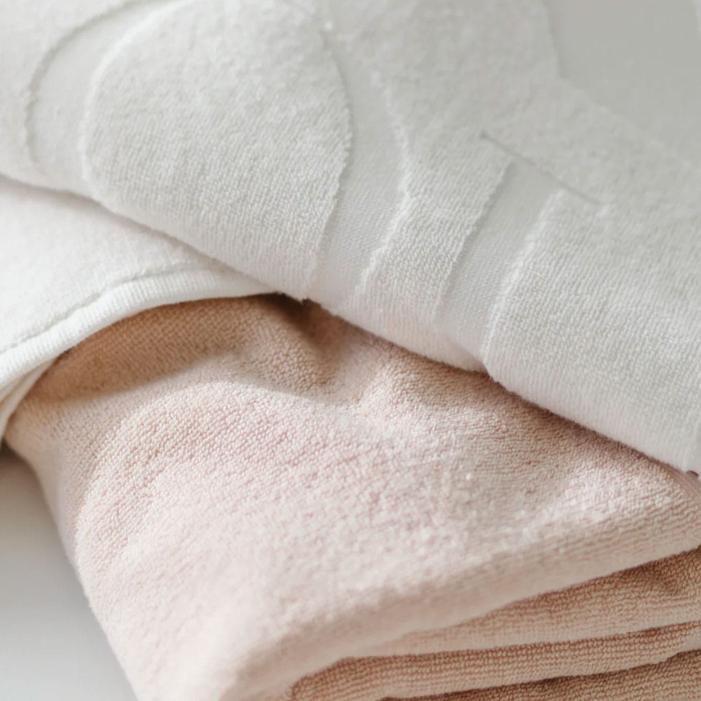 Närbild på en vit badhandduk över en rosa handduk.