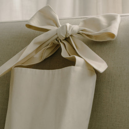 Bow bag på en grå soffa i vardagsrumsmiljö