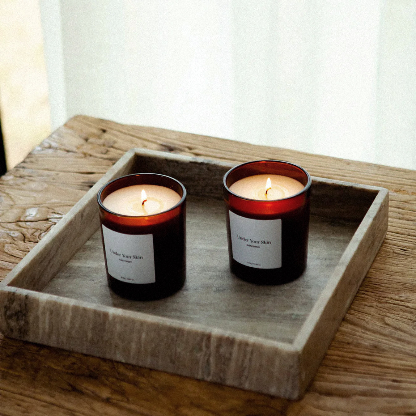 2st ljus på marmorfat på en träbord.