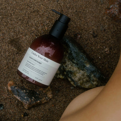 Produkt placerad på sandstrand med stenar intill och en fot bredvid