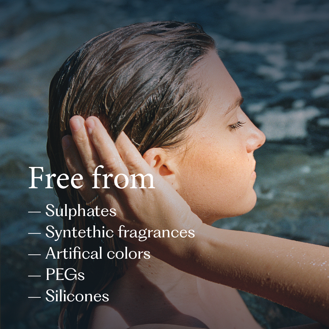 Kvinna i vatten med blött hår som kammar handen genom håret, med text som listar alla kemikalier produkten är fri från