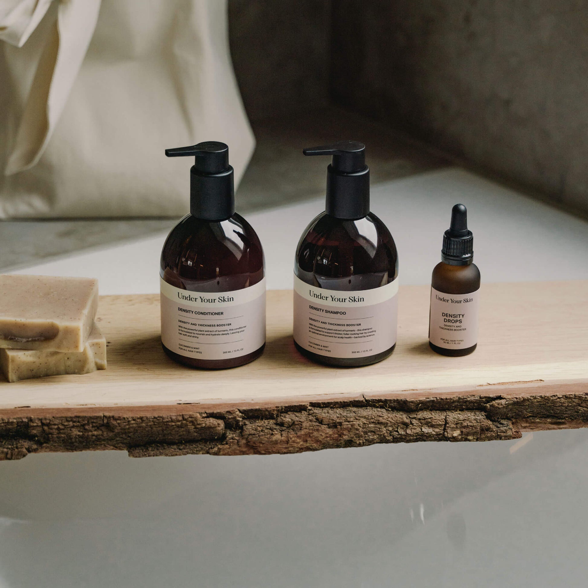 Hair Growth-produkter placerade på en träbit över badkarskanten i badrumsmiljö.