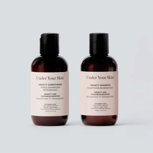 Two bottles of 'Under Your Skin' shampoo and conditioner on a light gray background