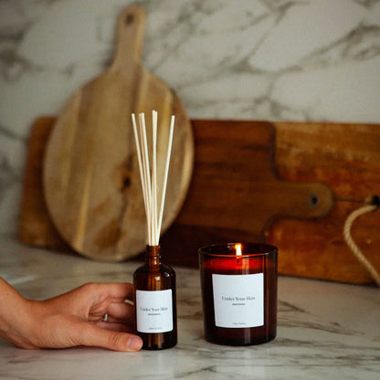 Ljus och olja på marmorbord.