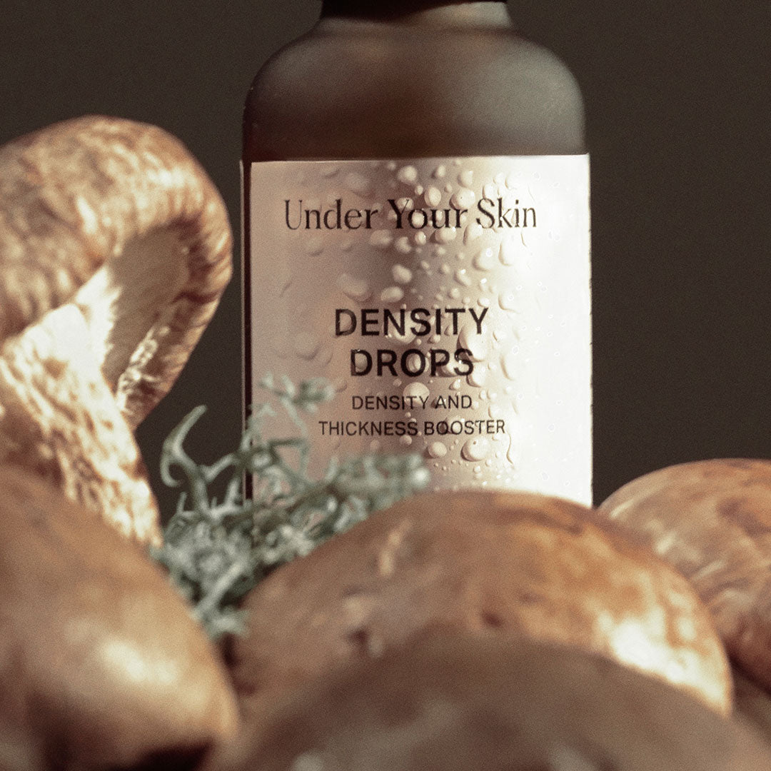 Close up on density drops bottle with some mushrooms on the front of the bottle.