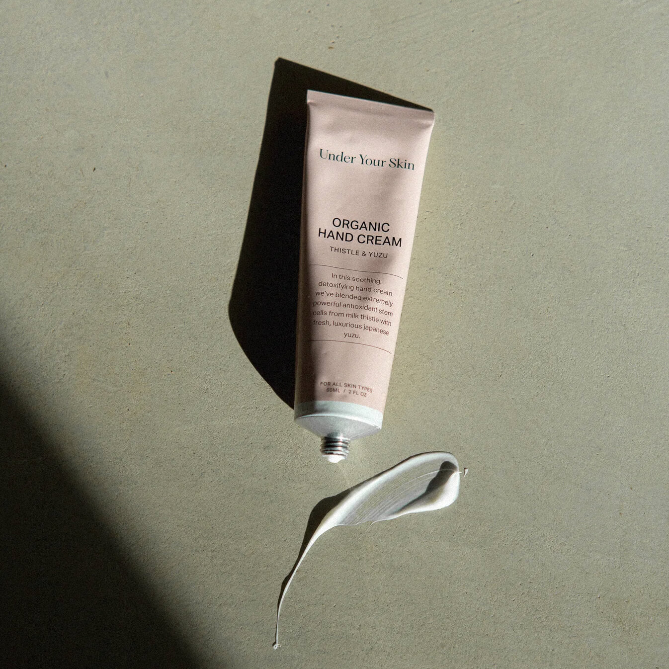 Öppnad burk med handkräm och texturprov.