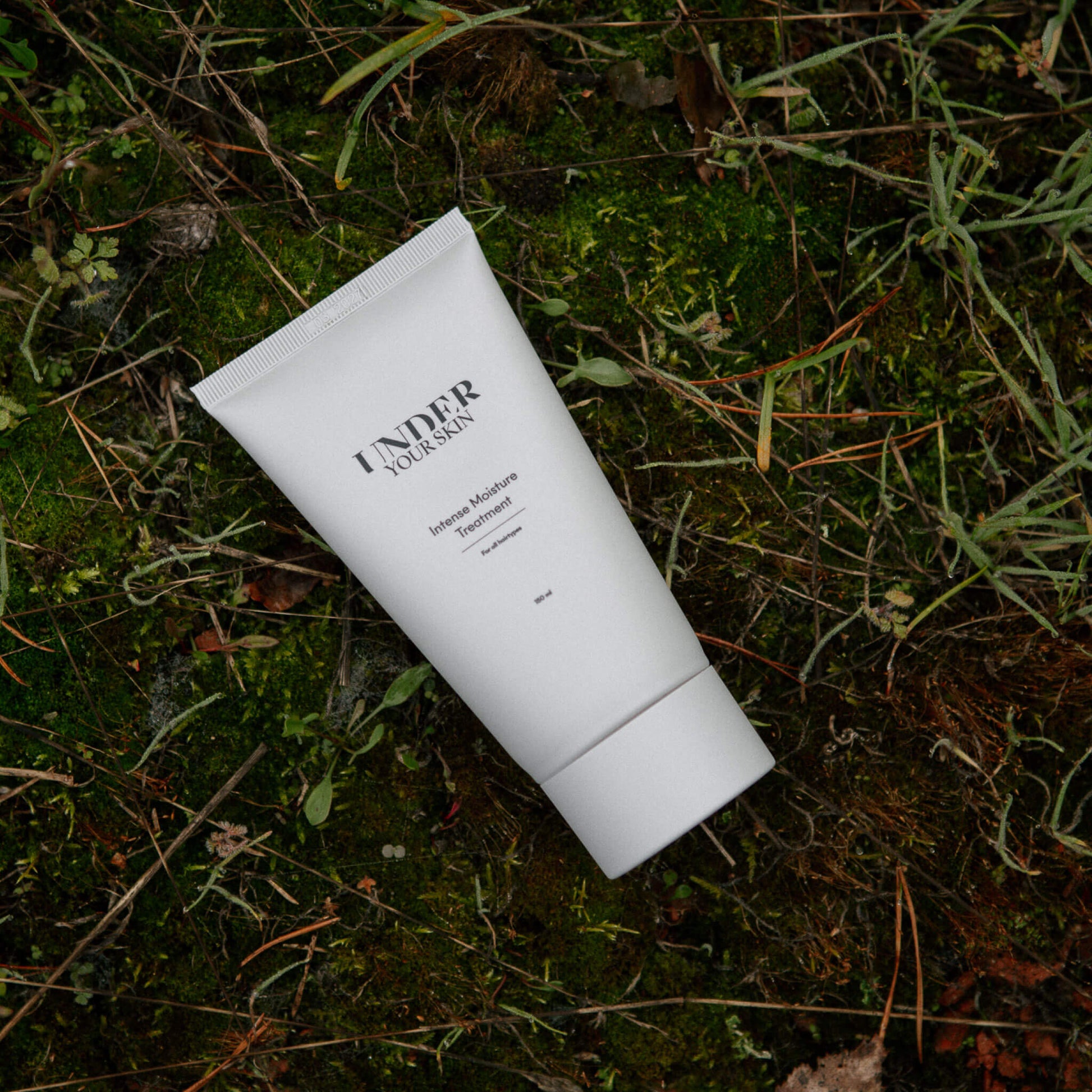 Hårmask placerad på naturmark med gräs och löv i en utomhusmiljö.