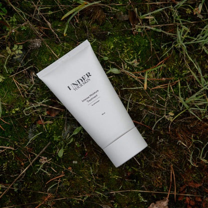 Hårmask placerad på naturmark med gräs och löv i en utomhusmiljö.