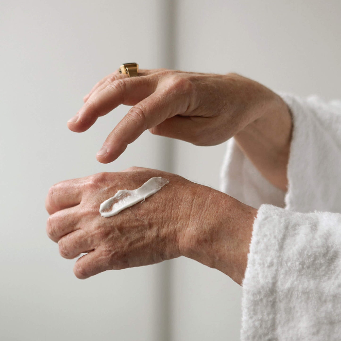 Äldre kvinnas händer med peelingmask på huden.