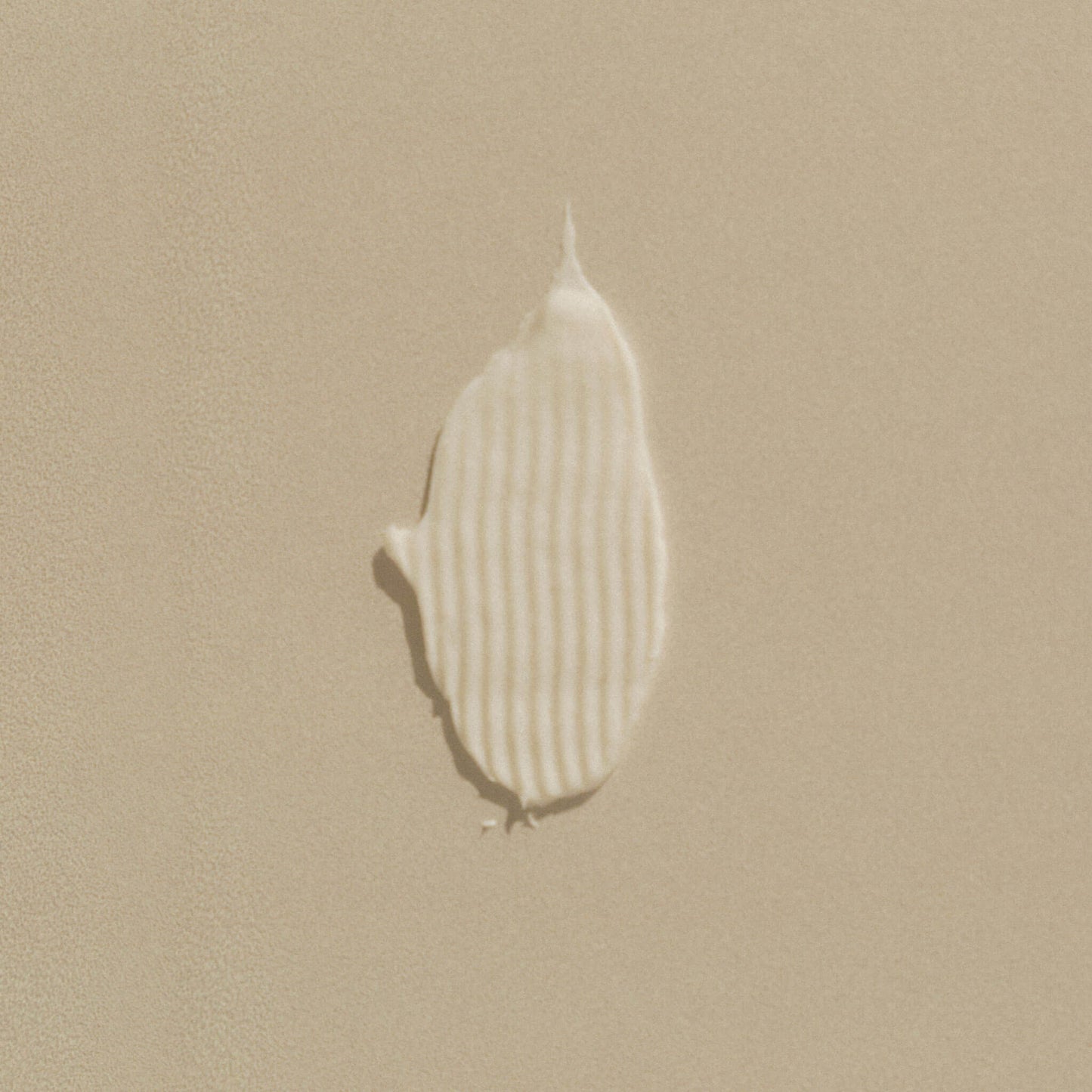 Balsamtest som visar textur på beige bakgrund.