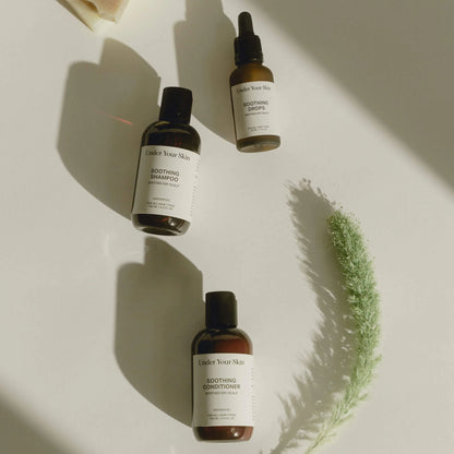 Travel size kit liggandes på vit bakgrund tillsammans med en växt på sidan.