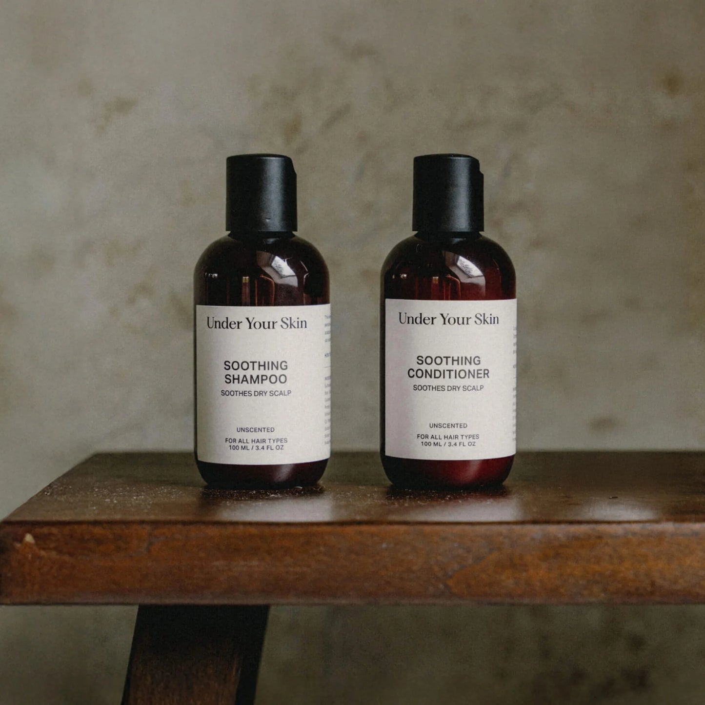 Scalp Treatment på en träbänk med en gråbeige vägg i bakgrunden.