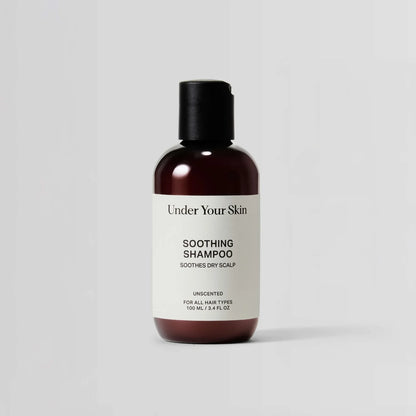 Bottle of 'Under Your Skin' soothing shampoo on a light gray background