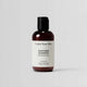 Bottle of 'Under Your Skin' soothing shampoo on a light gray background