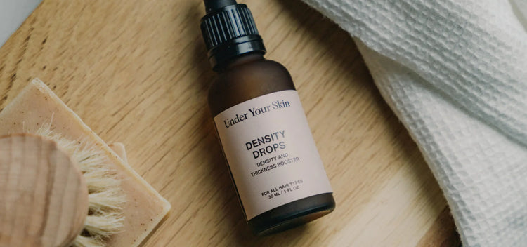 density drops on wooden surface with a wooden brush next to it.