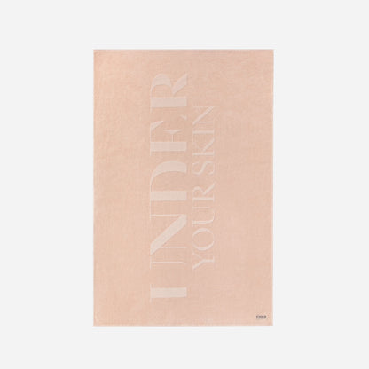 UYS rosa badhandduk på vit bakgrund.