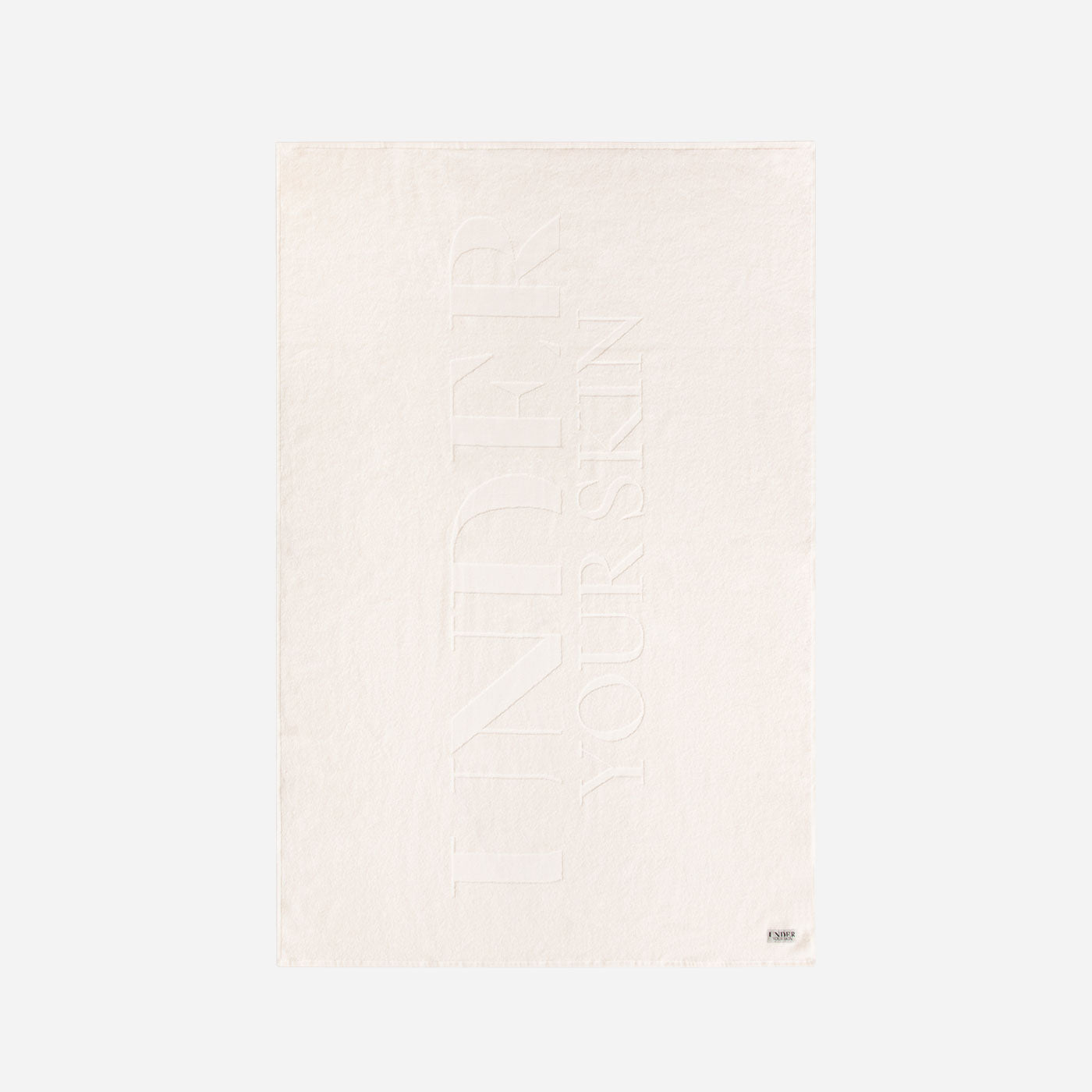 UYS vit badhandduk på vit bakgrund.