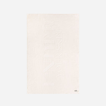 UYS vit badhandduk på vit bakgrund.